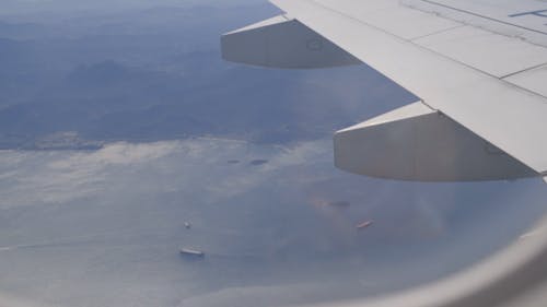 航空機の窓からの雪に覆われた地面と海の空撮