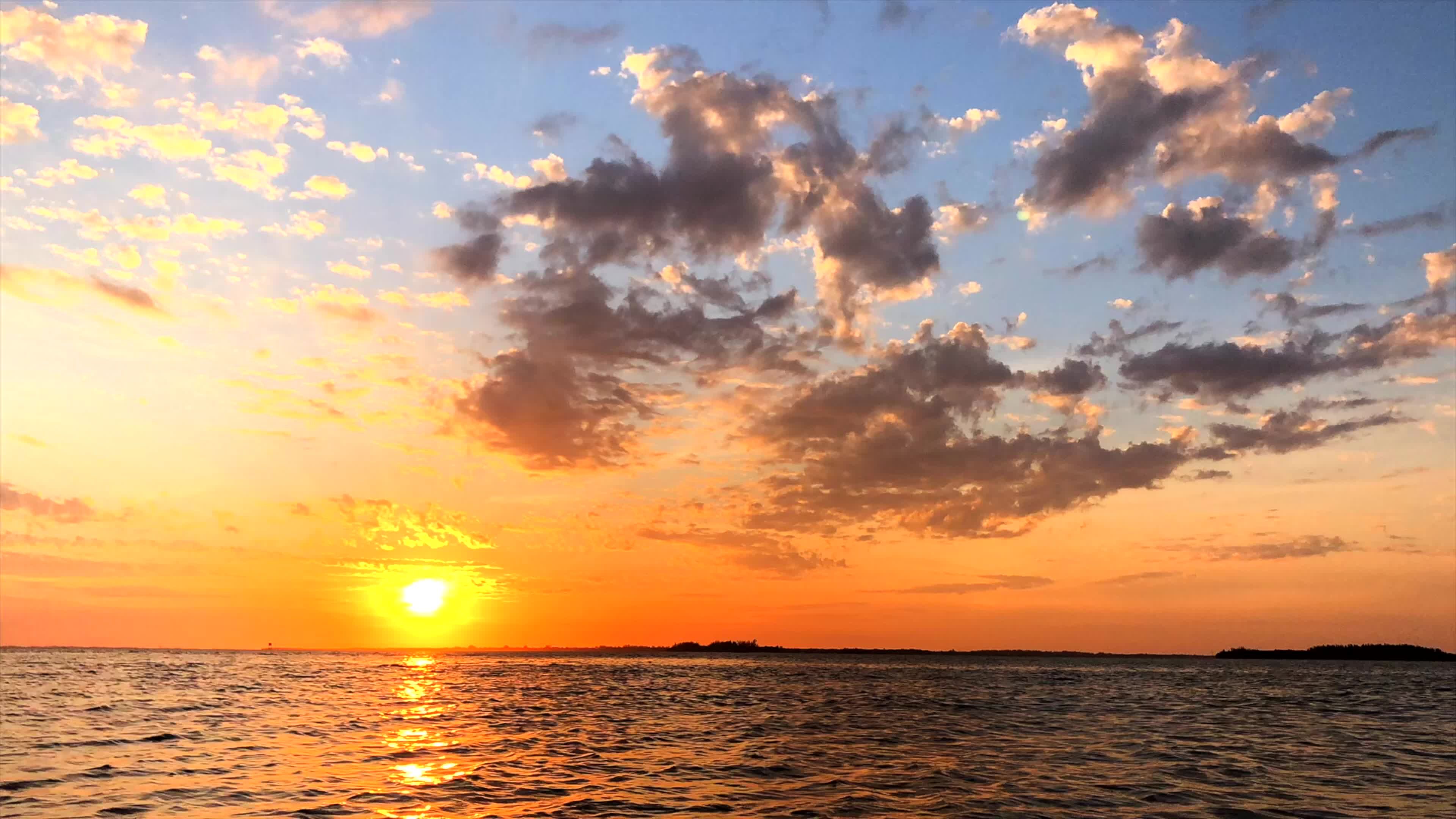 The sun sets over the water with clouds in the sky Free Stock Video ...