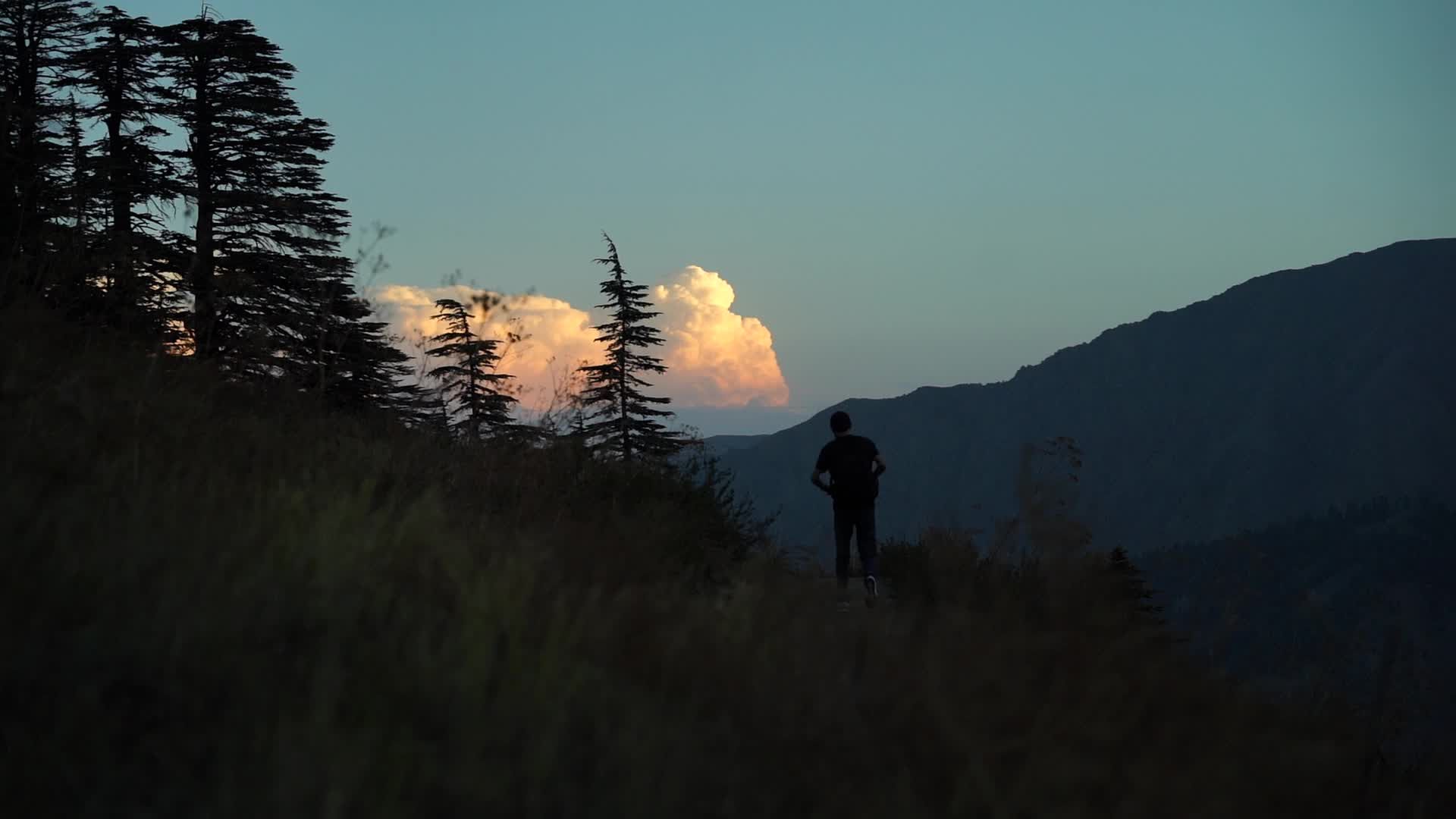 Silhouette of a Man Walking at Sunset in Mountainous Forest Free Stock ...
