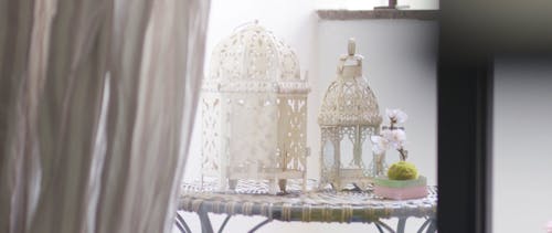 A White Table With Ornate White Lamps On Top