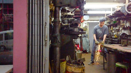 A Worker Grinds A Metal