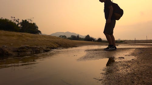 Man Jumping Over A River