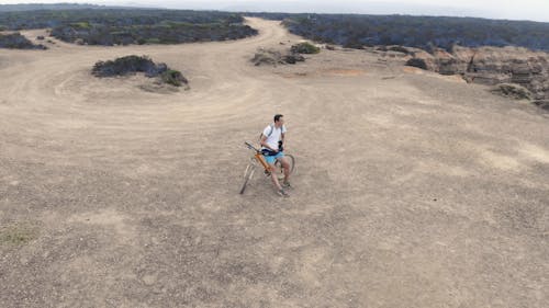 A Mounter Biker On Top Of A Plateau Over Looking The Sea