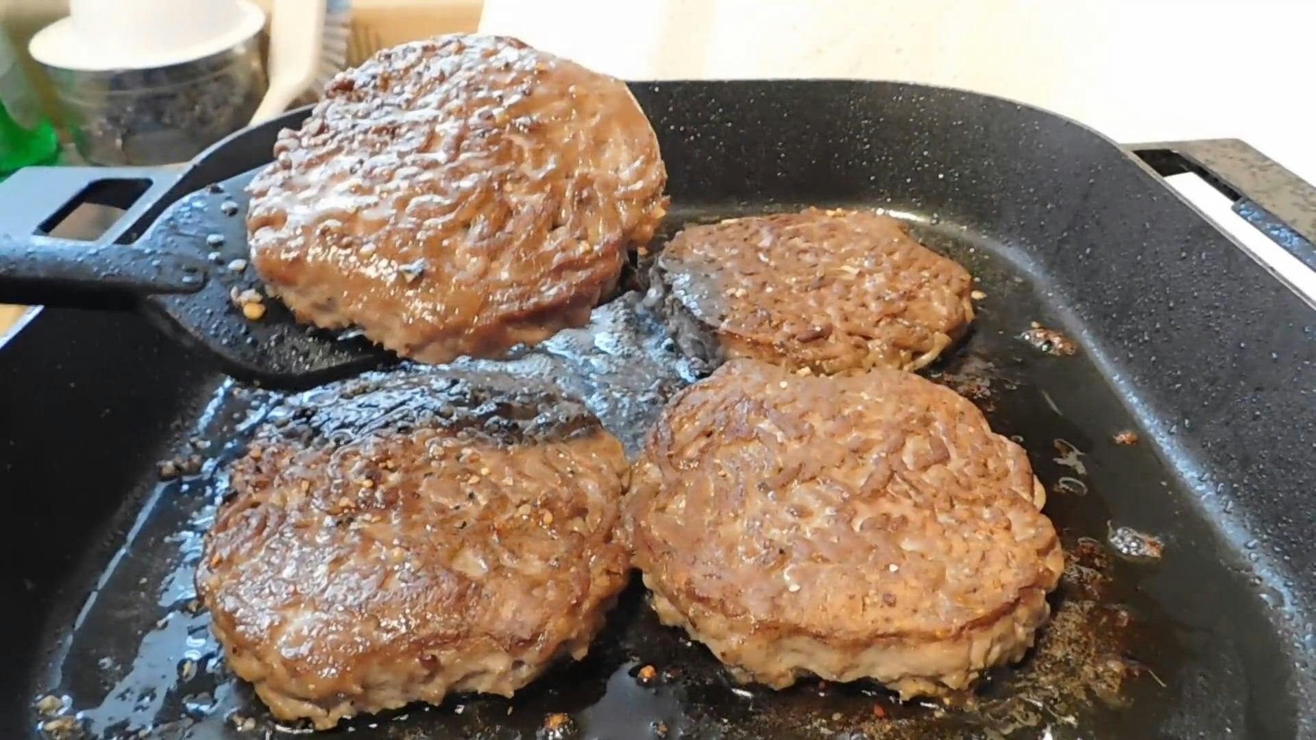 Closeup Of Juicy Burger Patties Cooking On A Skillet · Free Stock Video
