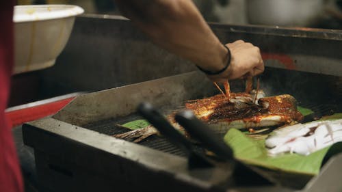 Grilling A Fish Over A Banana Leaves