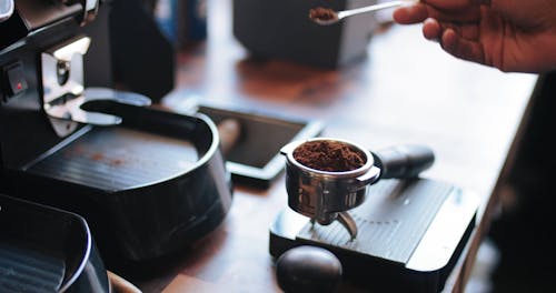  A Bartender Pressing Ground Coffee On A Filter Cup Of A Coffee Making Machine