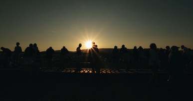 people watches the sunset from a view deck