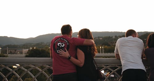 A Couple Show Their  Love By Kissing On A View Deck