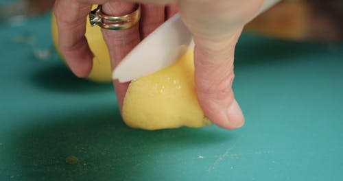 Close-up Of A Person Slicing Lemons On A Cutting Board In Slow Motion