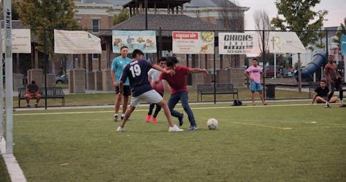 男の子のグループはサッカー場でサッカーをします