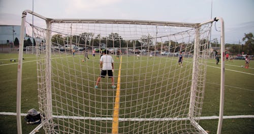 A Goalie Guarding The Net In A Game Of Football