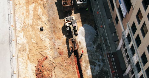 Aerial Footage Of A Backhoe At Work On A Construction Site