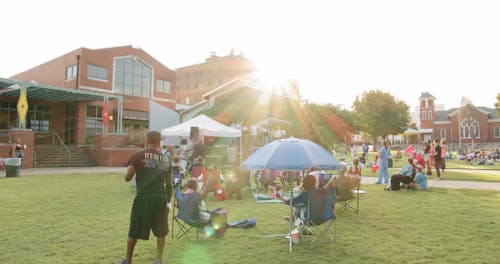 A Crowd Of People Gathers To Watch Performers On A Stage