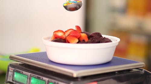 Person Weighing A Bowl Of Sweet Food