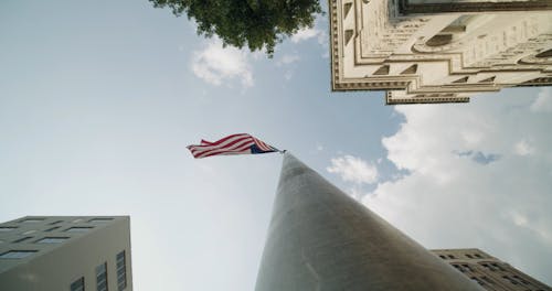 The American Flag Raised High In A Flag Pole