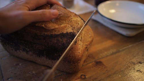 Slicing A Loaf Of Bread Using A Bread Knife