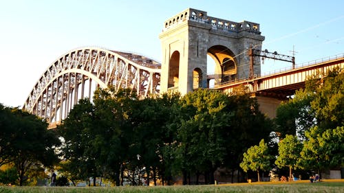 People Enjoying The Park Under The Hell Gate Bridge in New York