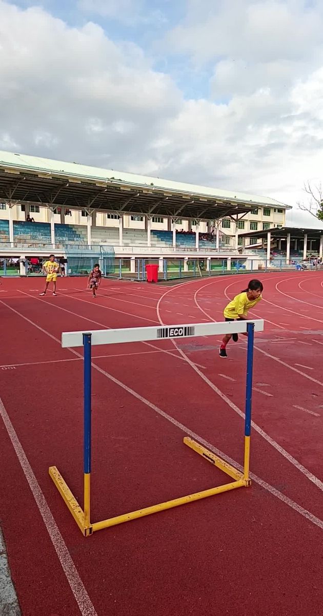 young athletes hurdle race at outdoor stadium 29996514