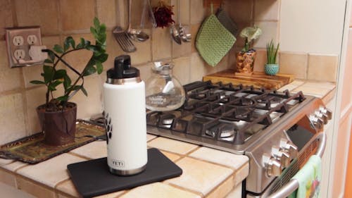 A Vacuum Flask On The Counter Besides The Stove