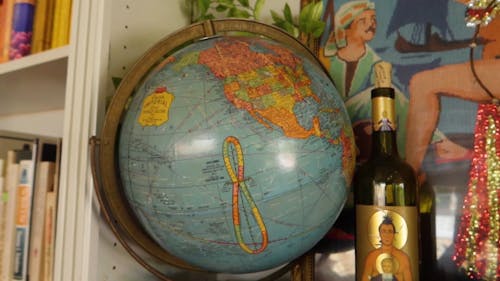 Close-up Footage OF A Globe On Top Of A Shelf Beside A Camera