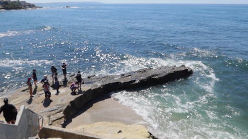 Menschen, Die über Einem Großen Felsenbett Am Ufer Mit Blick Auf Das Offene Meer Stehen
