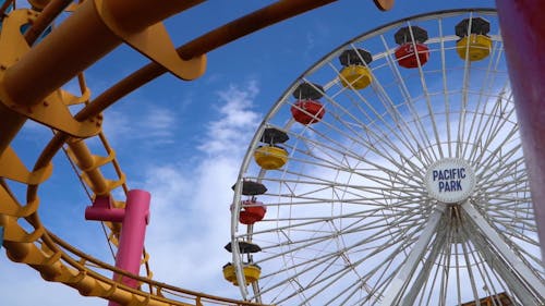 Parkta Hareket Eden Bir Dönme Dolap Ve Roller Coaster'ın Düşük Açılı Görüntüleri