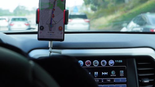 Driver Using Google Maps On The Cellphone Mounted On The Dashboard