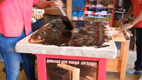 Охлаждение горячей шоколадной помадки на столешнице путем перемешивания ее лопатой