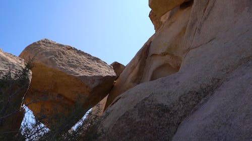 Каменный валун, перекрывающий разрыв между двумя массивными скальными образованиями