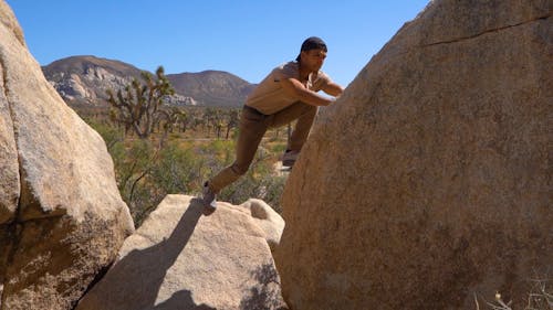 A Man Climbs On A Boulder Of Rock