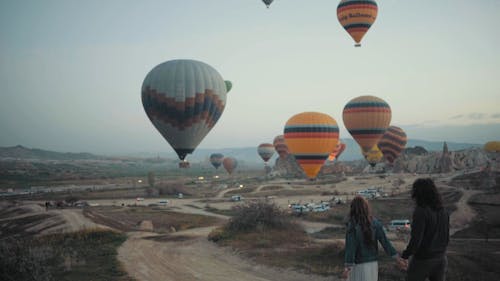 Пара идет по дороге к фестивалю воздушных шаров