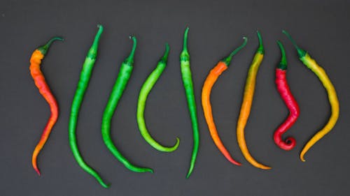 Chili Peppers Line Up Over A Black Surface