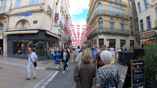 Una Calle Comercial Llena De Gente Y Tiendas De Marca.
