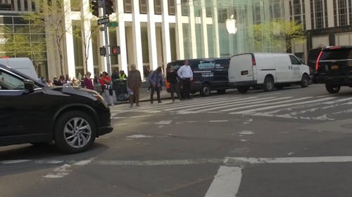 Pedestrians Waiting For Traffic Light To Cross A Street