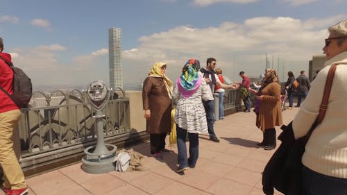 People On Top Of Building Overlooking The City