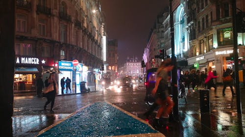 Gente Afuera De Las Calles En Una Noche Lluviosa
