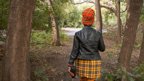 Parte Trasera De Una Mujer Caminando Fuera Del Bosque Hacia La Carretera