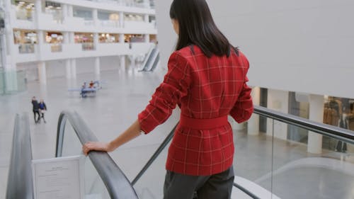 Una Mujer En Una Escalera Mecánica Bajando Mira De Lado A Lado