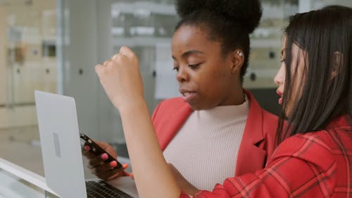 Deux Dames à La Recherche D'informations Et De Données Dans Un Ordinateur Portable Et Un Téléphone Intelligent