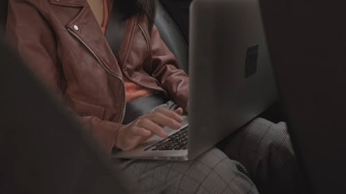 Женщина, работающая с ноутбуком внутри автомобиля