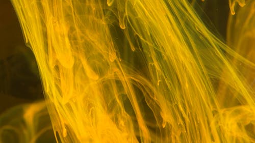 Yellow Ink Flows In Different Directions In Slow Motion