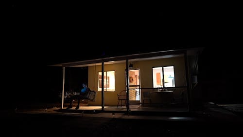 Person Sitting On A Swing In The Porch Of A House