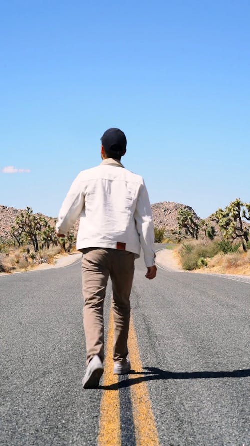 Man Walking On The Lane Of The Road