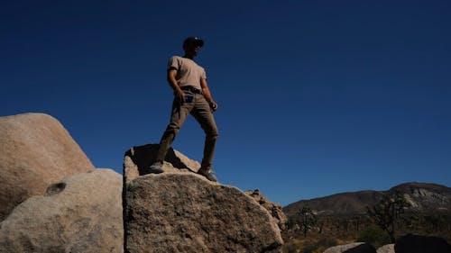 Man On A Rock While Searching For A Signal On His Phone 