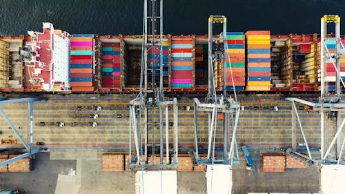 Heavy Machinery Used In Seaports Unloading Containers From A Cargo Ship 