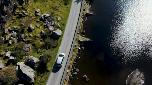 Ein Auto, Das In Einer Straße Fährt, Die Am See Gebaut Wurde