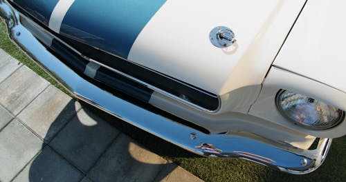 Close-up Of The Front Chrome Bumper Of A White Classic Mustang