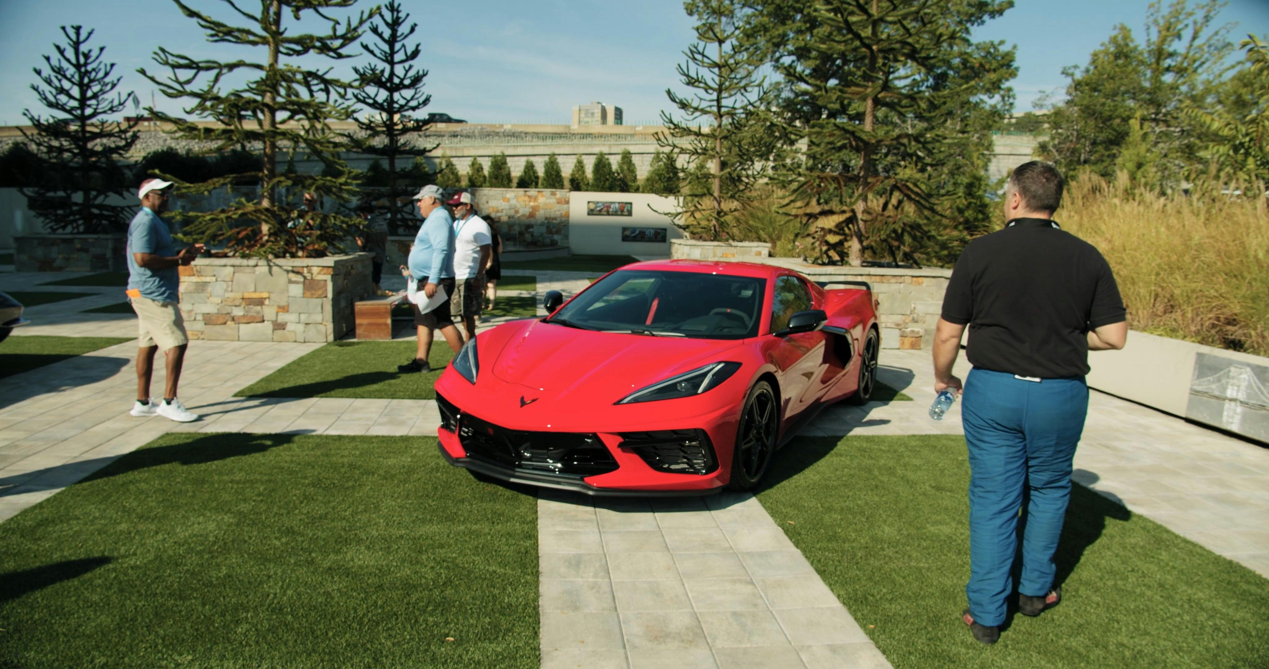 People Taking Pictures Of A Luxury Red Sports Cars Parked