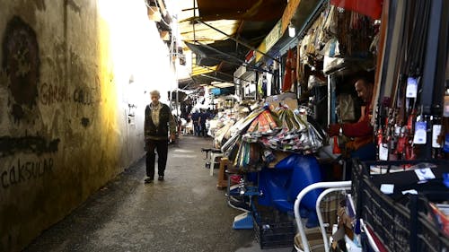 Gente Caminando En Un Callejón Bordeado Con Varios Establecimientos De Pequeñas Empresas Que Venden Una Variedad De Mercancías