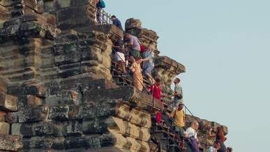 tourists climbing ancient angkor wat temple steps